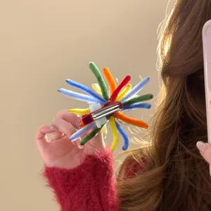 Close-up of a vibrant colorful flocked firework hair clip with unique handmade details