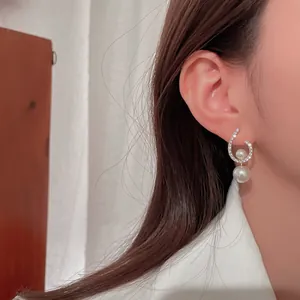 Detailed view of elegant silver needle twisted rhinestone and pearl earrings