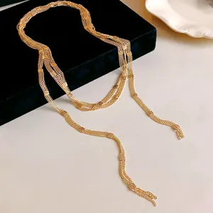 Detailed view of long multi-strand gold chain necklace with square link accents