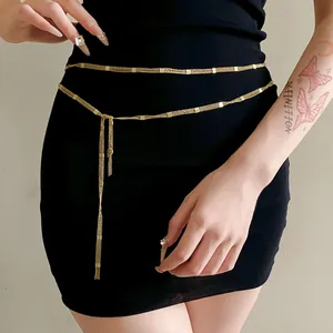 Close-up of minimalist gold waist chain layered on black dress for elegant styling