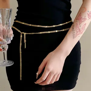 Detailed view of elegant gold multi-layer chain belt worn on a black dress