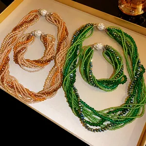 Detailed shot of multi-layer green and amber crystal beaded necklace and bracelet sets