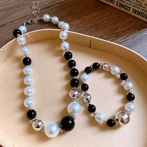 Fashionable black and white pearl necklace with silver metallic beads in geometric style