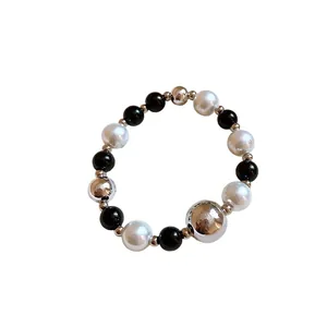 Fashionable elastic beaded bracelet with black, white pearls and silver spheres