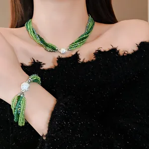 Close-up view of bohemian multi-layered green crystal beaded necklace and bracelet set with clasp