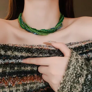 Close-up of bohemian multi-layer green crystal beaded necklace worn by a model