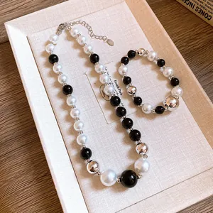 Close-up detail of the modern black, white, and silver geometric pearl necklace set