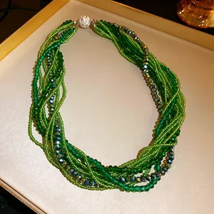 Close-up of multi-layer green crystal bead bracelet with sparkling rhinestone clasp