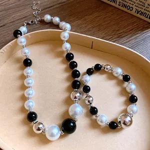 Close-up of irregular pearl and black bead necklace with silver accents