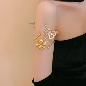 Detailed view of elegant gold butterfly and flower armlet with rhinestone accent on model