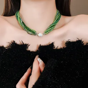 Close-up of multi-strand green crystal beaded choker necklace with rhinestone ball clasp