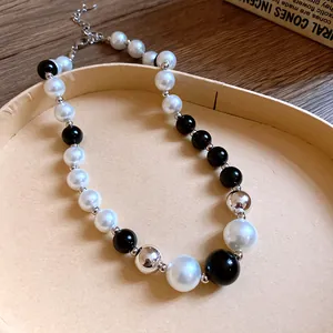 Detailed macro view of black and white pearl necklace with silver metallic accents