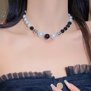 Detail view of irregular pearl and geometric black and white bead necklace on model
