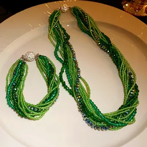 Detailed macro view of a Bohemian green multi-strand beaded necklace and bracelet jewelry set.