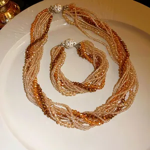 Detailed view of multi-layered amber crystal necklace and bracelet set on plate