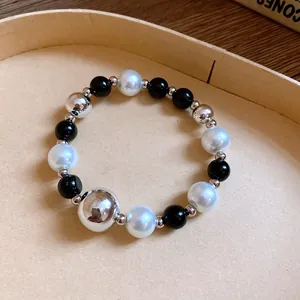 Detailed macro view of beaded bracelet with black, white pearls and silver beads