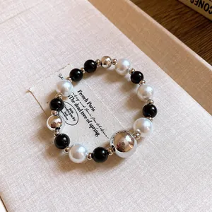Detailed macro view of geometric contrast beaded jewelry with pearl and silver beads
