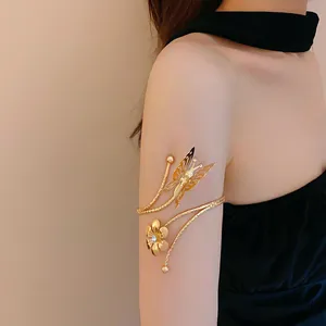 Close-up view of elegant golden flower and butterfly arm cuff with sparkling rhinestone detail