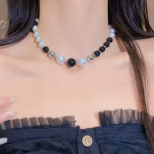 Close-up view of a stylish black and white irregular pearl necklace on a model's neck