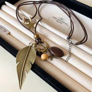 Detailansicht der ethnischen Lederhalskette mit Bronze-Feder- und Sternanhängern
