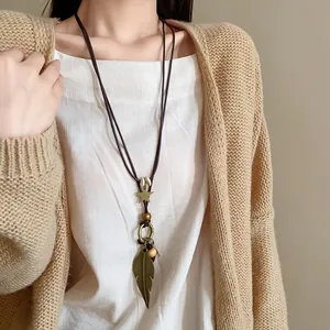 Detailansicht einer ethnischen Lederkette mit Feder- und Sternanhängern im Retro-Stil