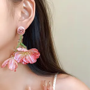 Detailed view of elegant pink floral mesh tassel earrings with crystal droplets on a model