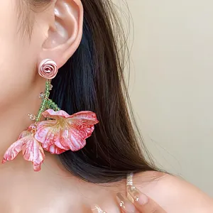 Close-up of sweet floral mesh tassel earrings worn by a model