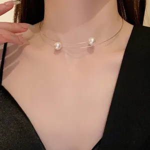 Minimalist steel wire choker with two pearls worn by model, elegant fashion jewelry accessory.