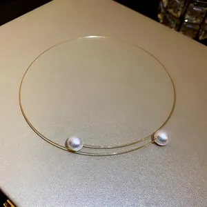 Minimalist gold-plated wire collar necklace featuring two elegant white pearl accents.