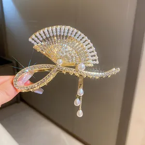 Exquisite gold-tone fan-shaped hair claw clip decorated with pearls, rhinestones and tassel.