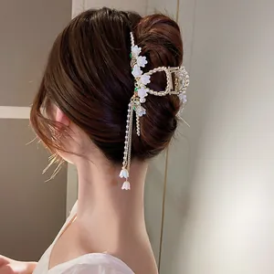 Elegant lily of the valley hair claw clip with pearl tassels in a sleek back bun hair style