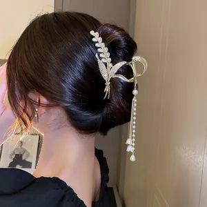 Elegant rhinestone pearl lily of the valley hair claw clip with long tassel shown on model