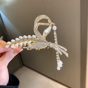 Detailed view of luxury rhinestone wheat ear hair claw clip with pearl lily tassel