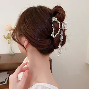 Detailed view of an elegant lily-of-the-valley hair claw clip with pearl tassels.