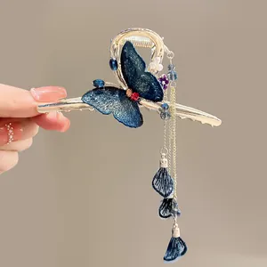 Close-up detail of luxury blue butterfly hair claw clip with elegant dangling tassels