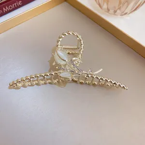 Close-up view of a luxury golden lily of the valley hair claw clip with rhinestones