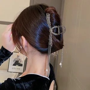Detail showing elegant hair claw clip with rhinestone tassels and pearl lily decorations