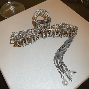 Detailed shot of an elegant silver hair claw with rhinestones and pearl tassels