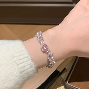 Primo piano di un elegante bracciale di perle rosa a doppio strato con zircone rosa centrale