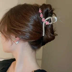 Detail of elegant rhinestone hair claw clip with pink flowers in a stylish updo