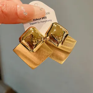 Close-up detail of elegant gold-plated brushed diamond earrings for women jewelry