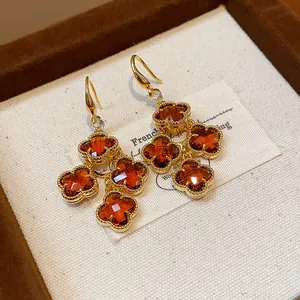 Close-up of vintage 18k gold plated clover earrings with orange zircon
