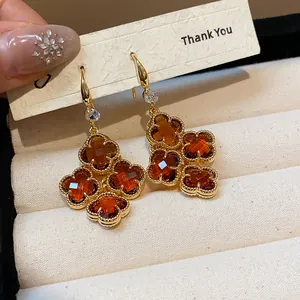 Detailed view of 18k gold plated earrings with amber clover-shaped stones