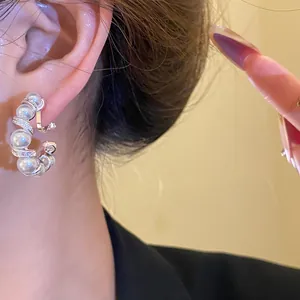 Gros plan d'un élégant clip d'oreille en C torsadé avec perles et détails en zircon