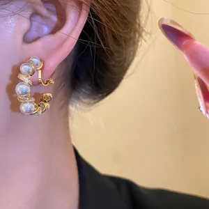 Gros plan détaillé d'une boucle d'oreille clip perle en forme de C plaquée or 18 carats