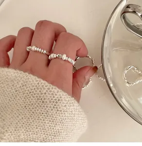 Detailed close-up view of elegant irregular pearl and silver bead elastic rings on hand