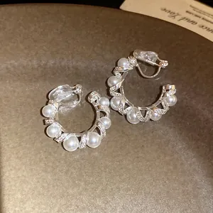 Détail rapproché de boucles d'oreilles clips en C avec perles élégantes et zircons