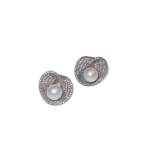 Elegant silver stud earrings featuring geometric pavé crystals and a lustrous central pearl.