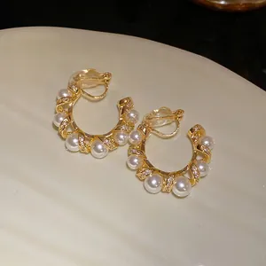 Gros plan de boucles d'oreilles clips en forme de C torsadé avec perles et zircons