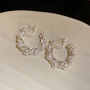 Vue détaillée de boucles d'oreilles clips en C torsadées avec perles élégantes et pierres pavées